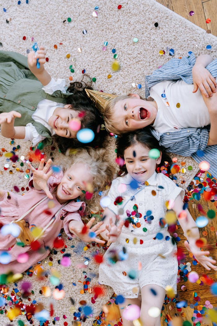 Mastering the First Impression: Your intriguing post title goes here Four happy children enjoy a party, lying on the floor with colorful confetti showering around them.