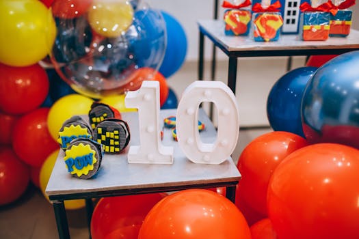pexels photo 10336805 10336805 Vibrant celebration setup with balloons, number 10, and superhero-themed cupcakes.